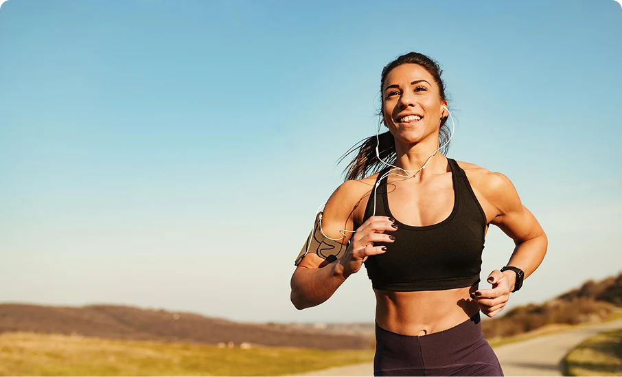 Woman running outdoors with earbuds